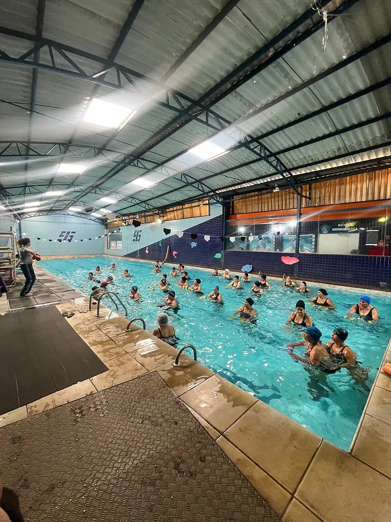 Turma de hidroginástica em grupo na piscina coberta