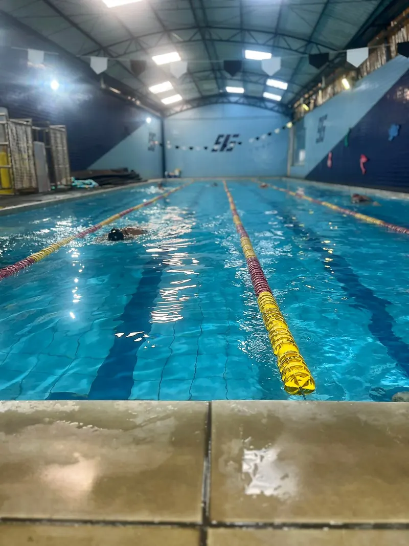 Piscina semi-olímpica com alunos nadando