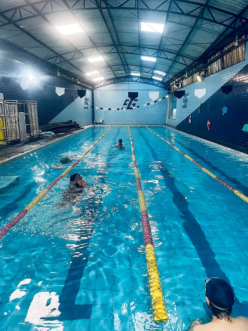 Alunos em aula de natação nas raias da piscina