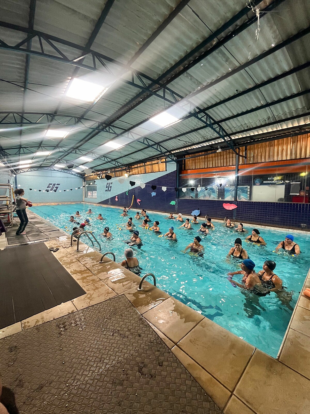 Turma de hidroginástica em grupo na piscina coberta