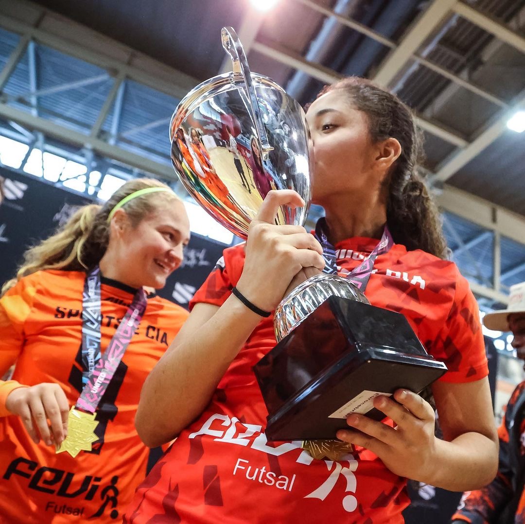 Atleta da Sports Brasil beijando troféu em Barcelona 2023